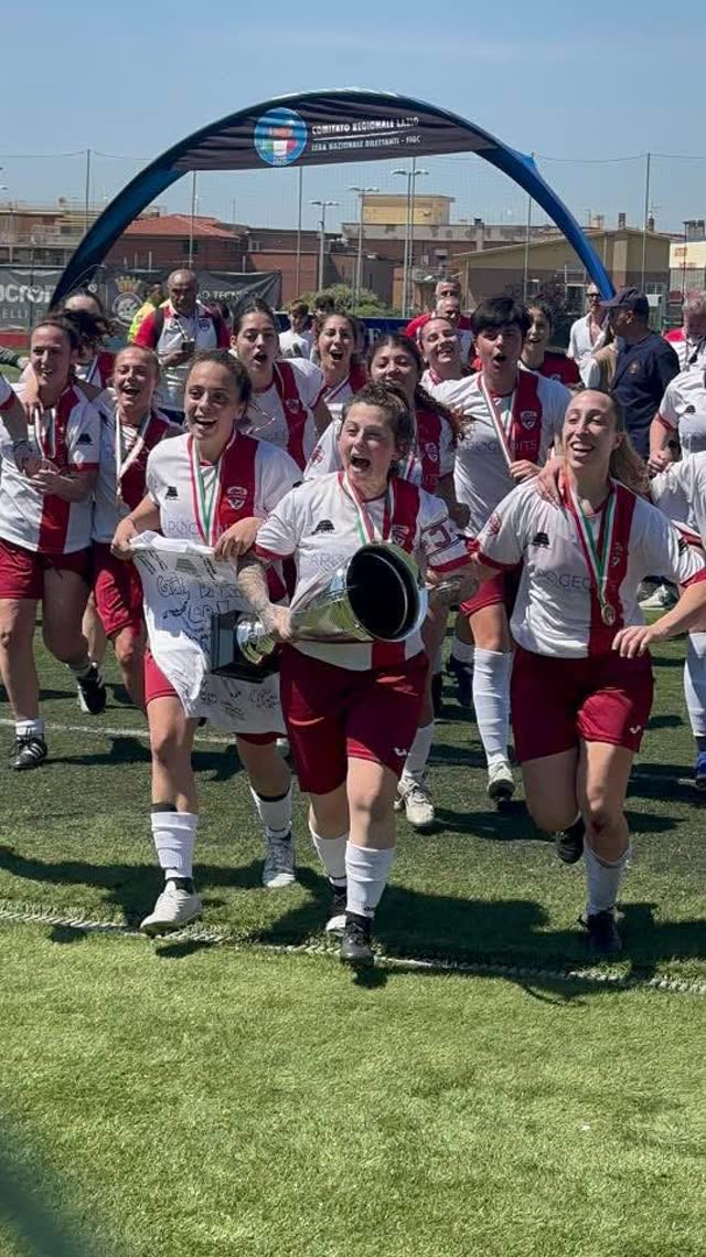 Le ragazze corrono con la coppa sotto l'arco della premiazione