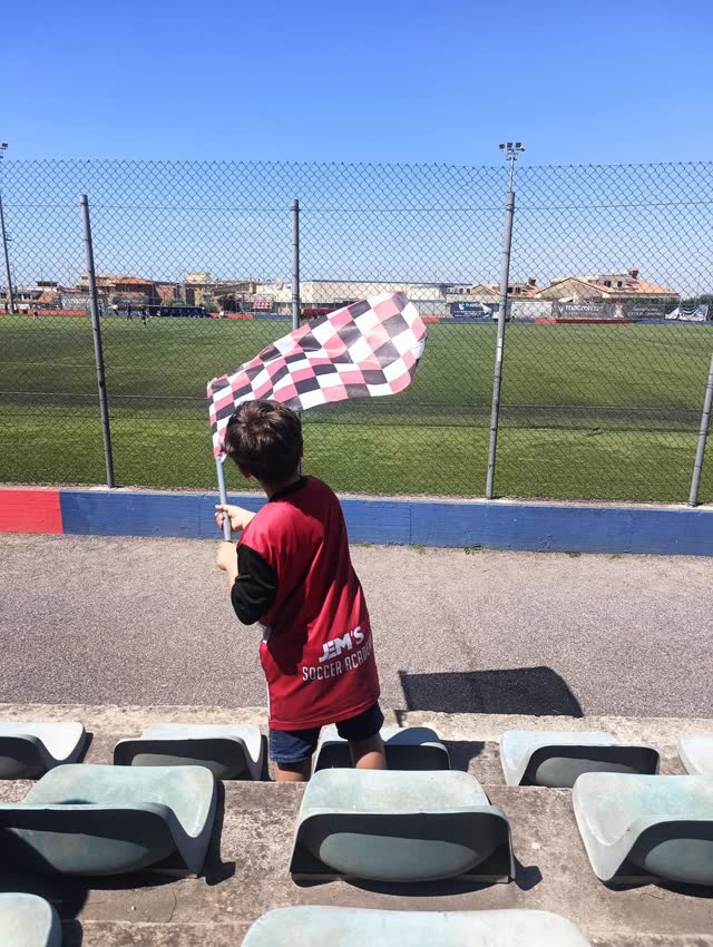 Un giovane tifoso sventola la bandiera sugli spalti
